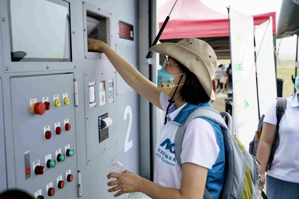 志工們將拾起的寶特瓶投入「好歸塑專車」，讓廢棄塑料空瓶可以直接粉碎、縮小體積，未來將可再製成購物袋、寶特衣、悠遊卡等生活用品